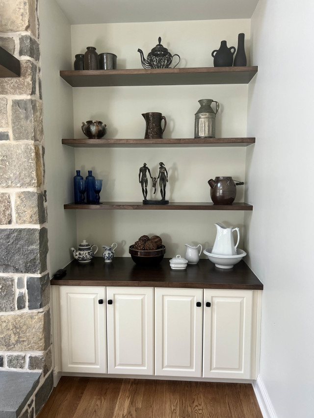 This built-in combines open shelving and cabinetry to provide practical storage and display options, enhancing the room’s functionality.