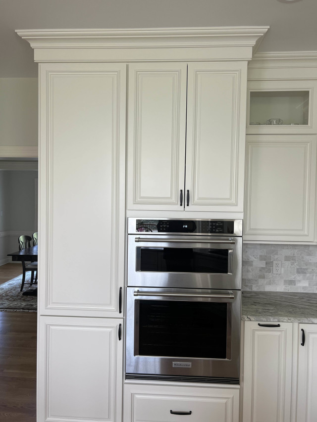 Custom Cabinetry with Double Ovens
Floor-to-ceiling cabinets frame the double ovens, maximizing storage and giving the kitchen a streamlined appearance. Applied molding on the cabinet doors adds depth and texture, elevating the overall look.