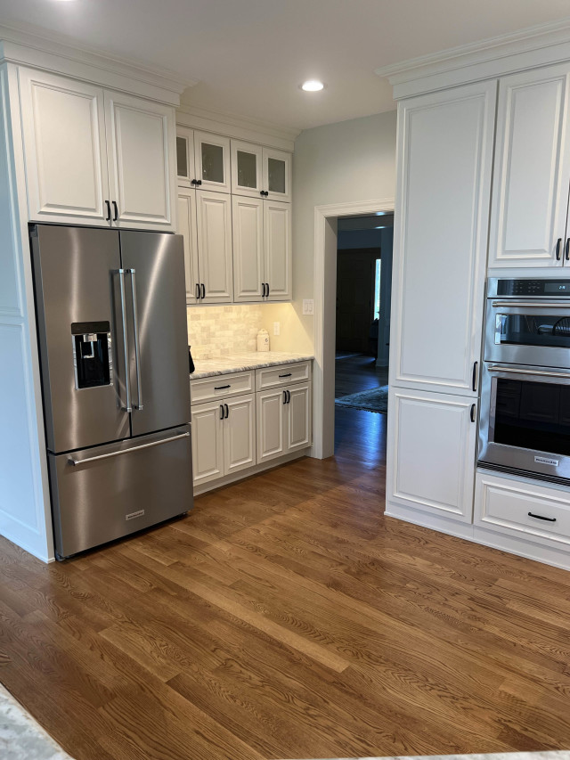 Custom Pantry Cabinetry
Custom cabinets with a dedicated pantry section improve organization while maintaining the kitchen’s clean lines. The backsplash adds a textured contrast to the sleek cabinetry and counters.