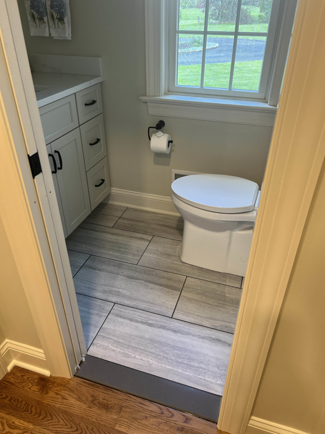 Powder Room Pocket Door and Tile Flooring
The updated tile flooring is durable and easy to maintain, while fresh paint and fixtures brighten the space. Pocket door on the left.