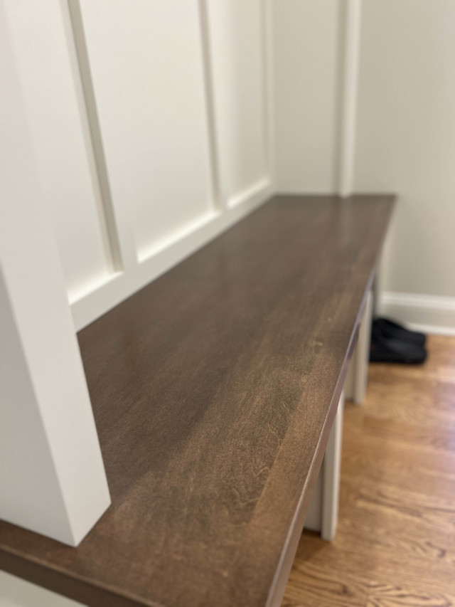 Bench Detail with Wainscoting
The wooden bench surface contrasts with crisp white cabinetry, with wainscoting adding subtle texture to the design.