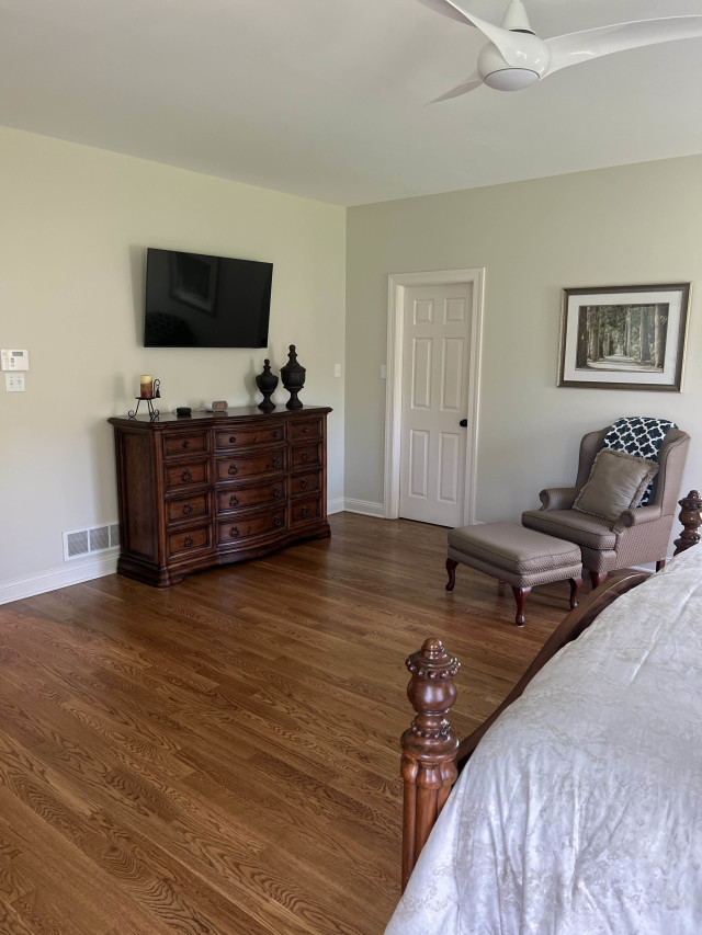 Refinished Flooring and Modernized Trim
The refinished hardwood and new trim work bring warmth and sophistication to the bedroom, complementing its traditional furniture.