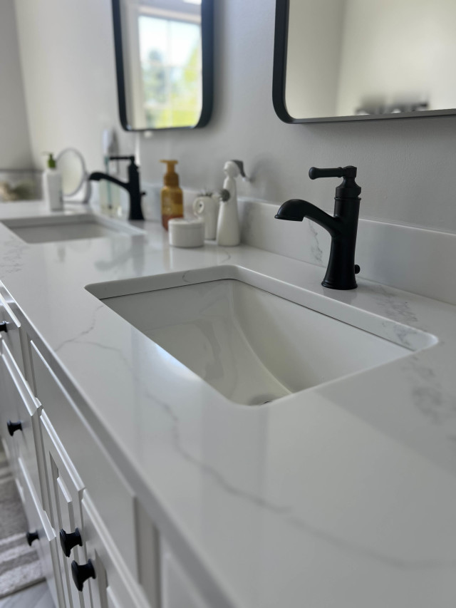 Updated Sink Area with Clean Lines and Modern Fixtures We installed a new vanity to match the tub deck with quartz countertops and matte black fixtures to add contrast and a contemporary edge.