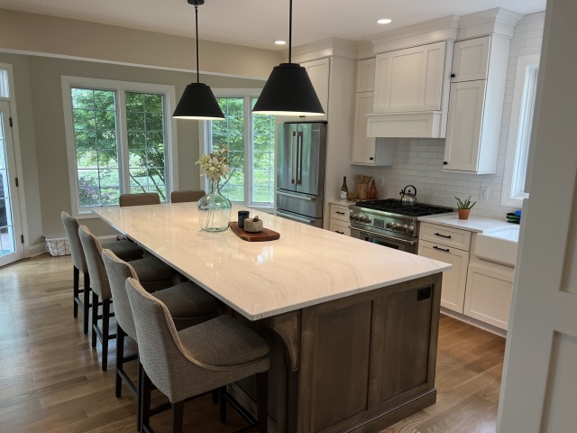 Custom-built-in cabinets and natural wood shelves frame the fireplace, blending storage with design while complementing the natural stone feature.