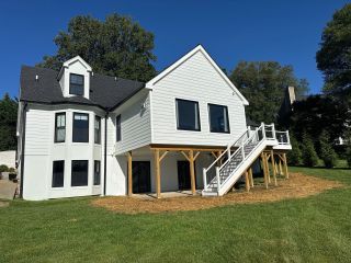 Side exterior view of elevated Landenberg home addition with new stairs and covered patio below.