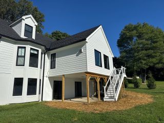Finished two-story home addition and deck viewed from the yard in Landenberg Pennsylvania.